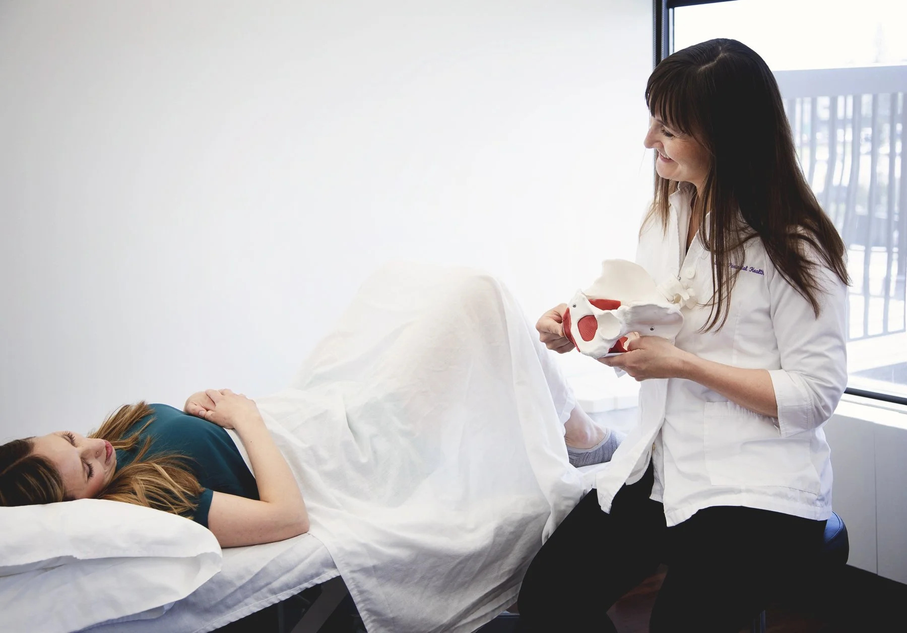 A physiotherapist caring for a client at Optimum Perinatal Health