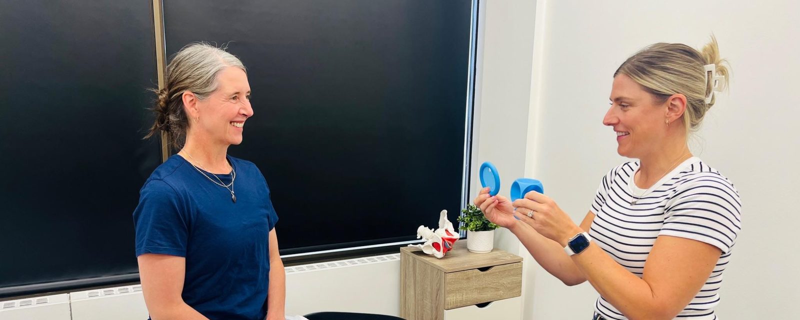A physiotherapist showing a client the pessary options during a fitting consultation